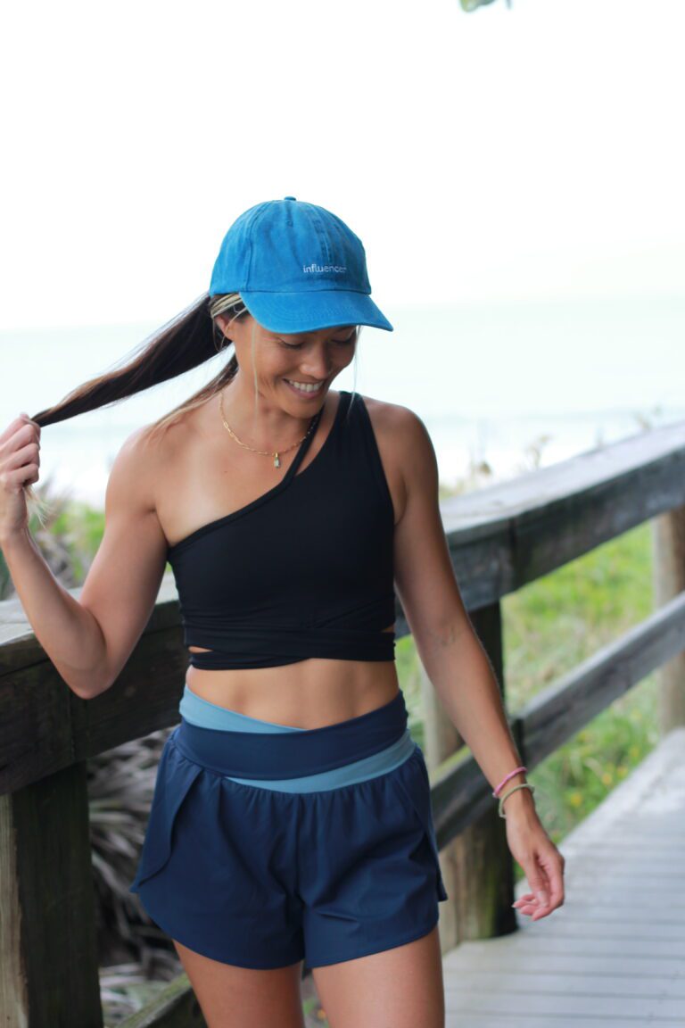 Woman in black activewear on a beach boardwalk — coastal living on the Space Coast