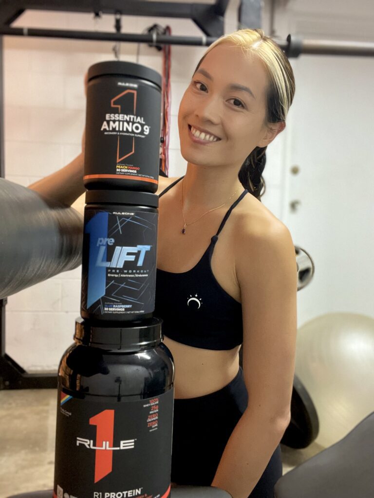 Woman holding a pre-workout supplement at the gym — fitness in your 30s