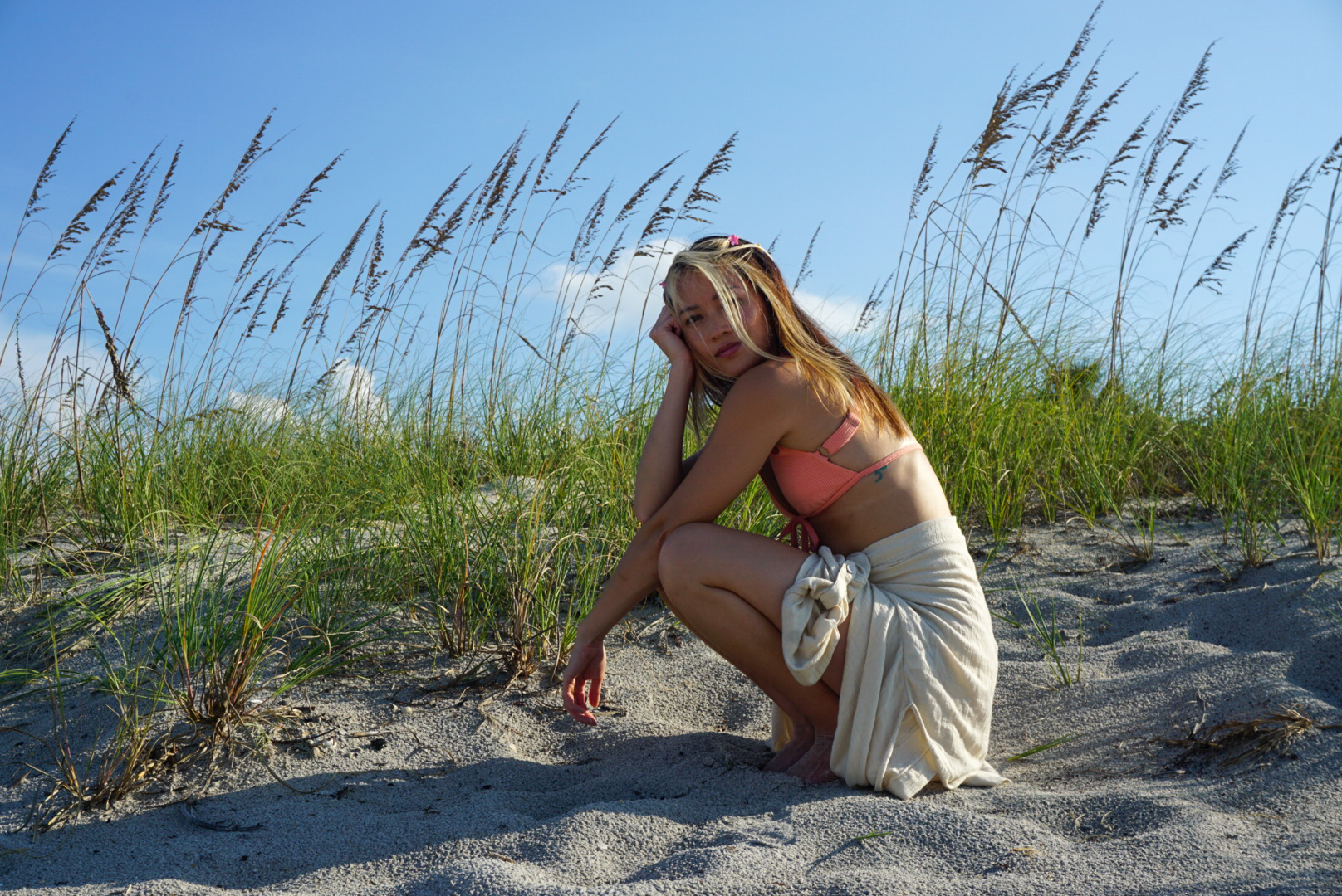 Confident woman in her 30s posing on the beach