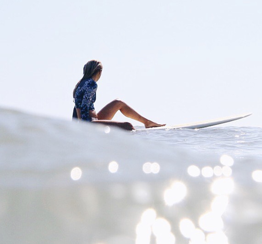 woman sitting on surfboard in the ocean
