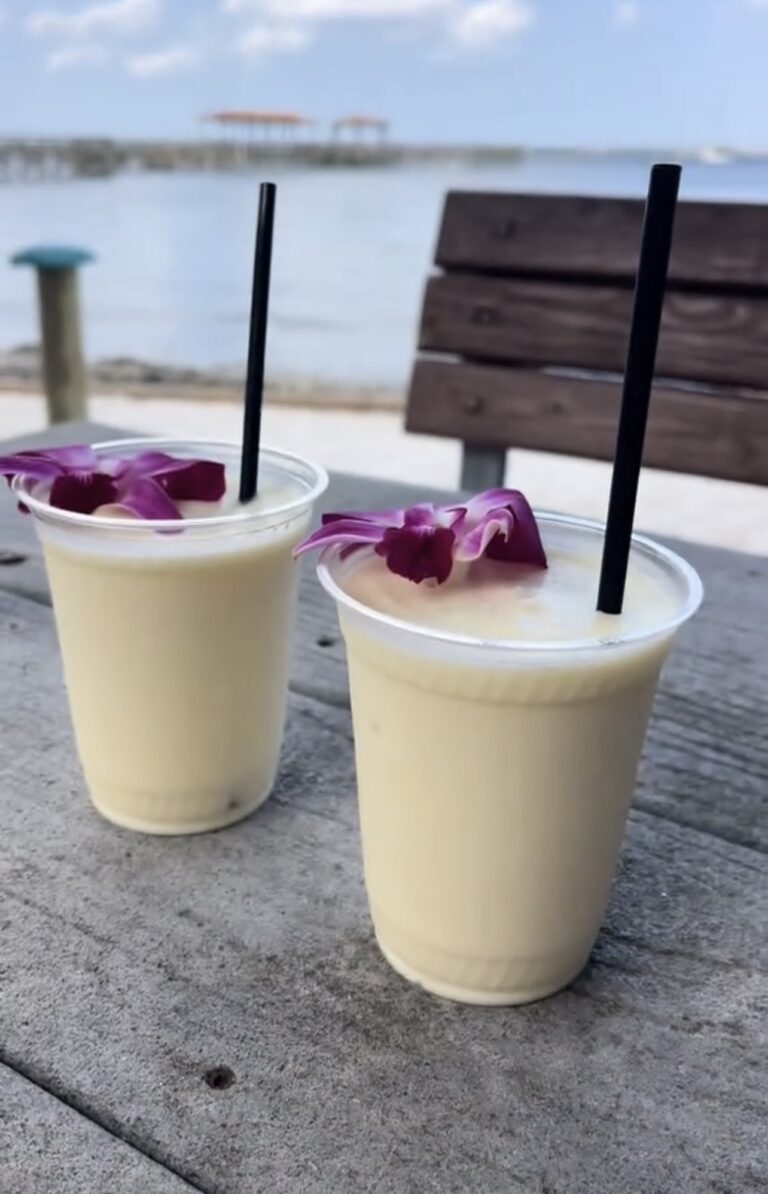 Two tropical drinks by the water