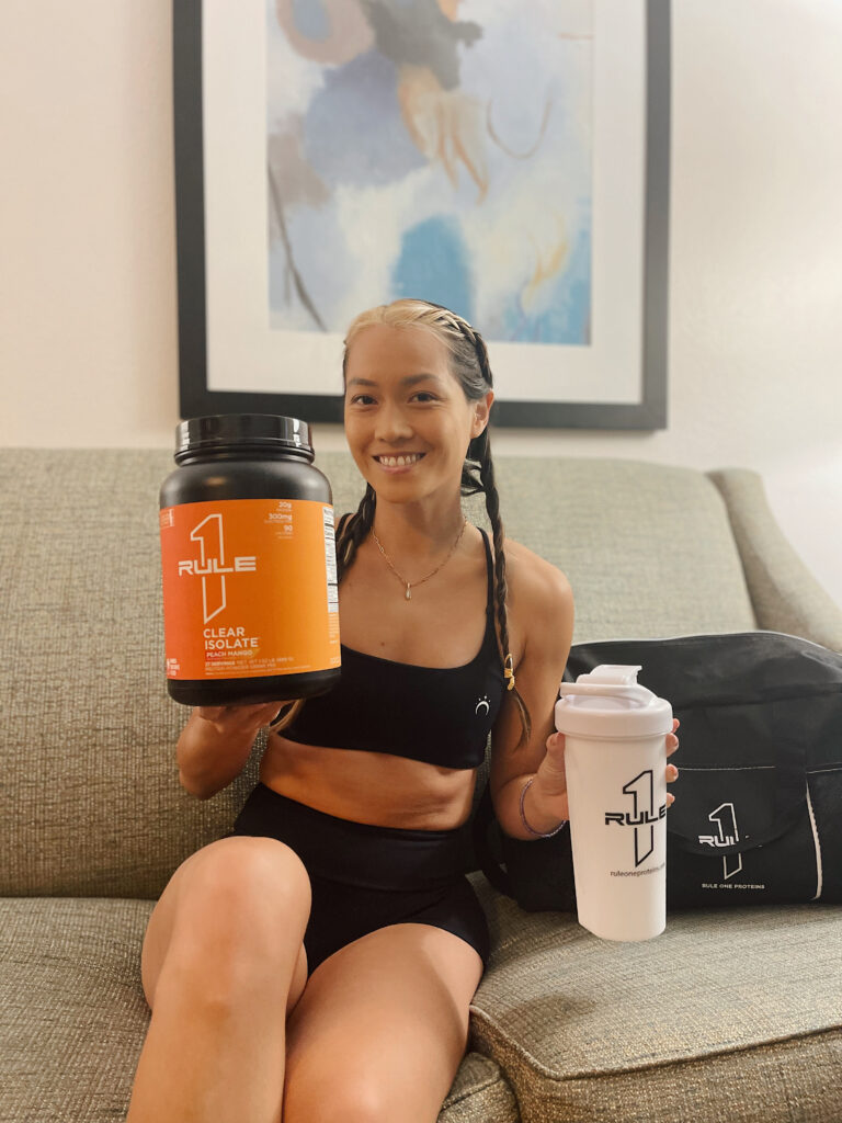 Person holding protein powder and shaker.