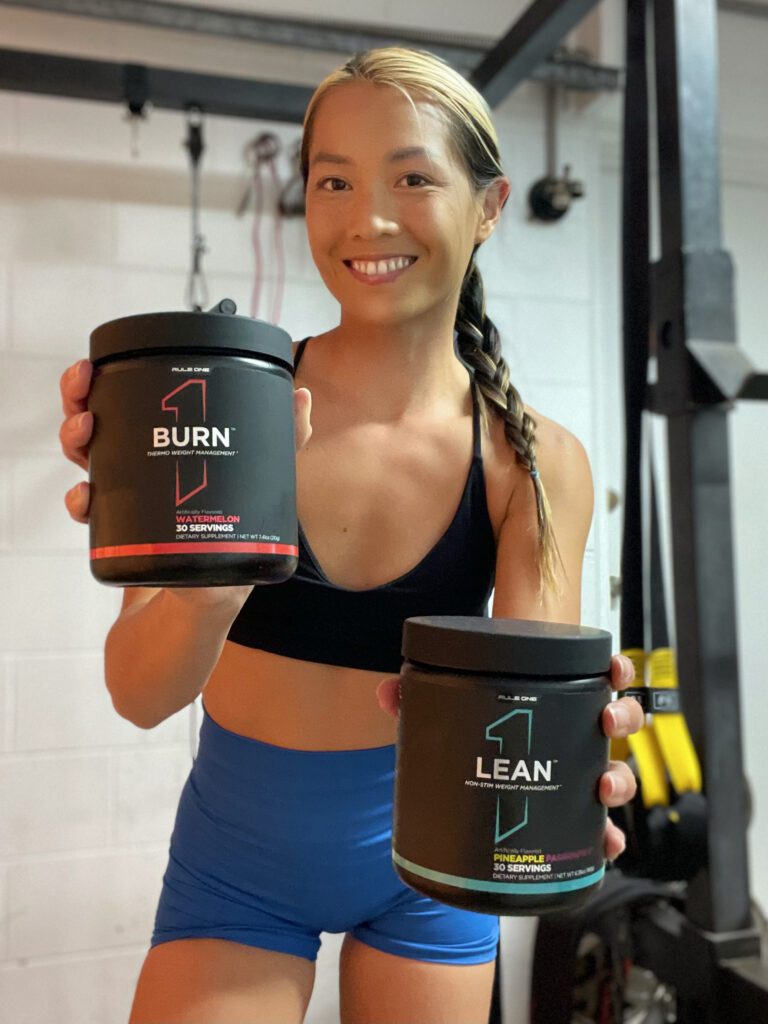 Person holding fitness supplement containers.