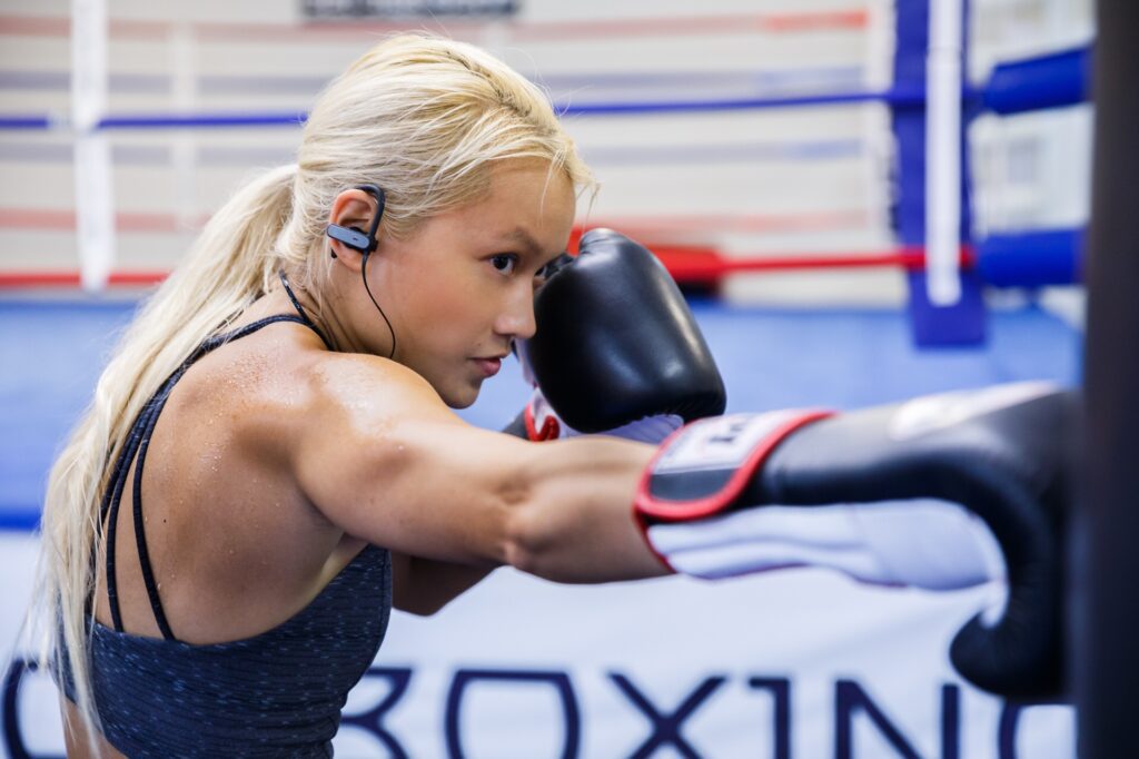 Throwing a punch into pads while training in boxing gloves at the gym