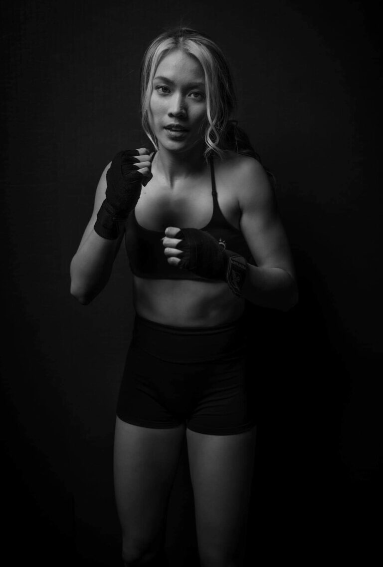 Woman kickboxing in a black sports bra