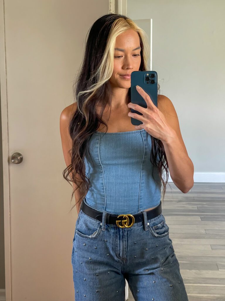 Woman taking a mirror selfie in a blue top