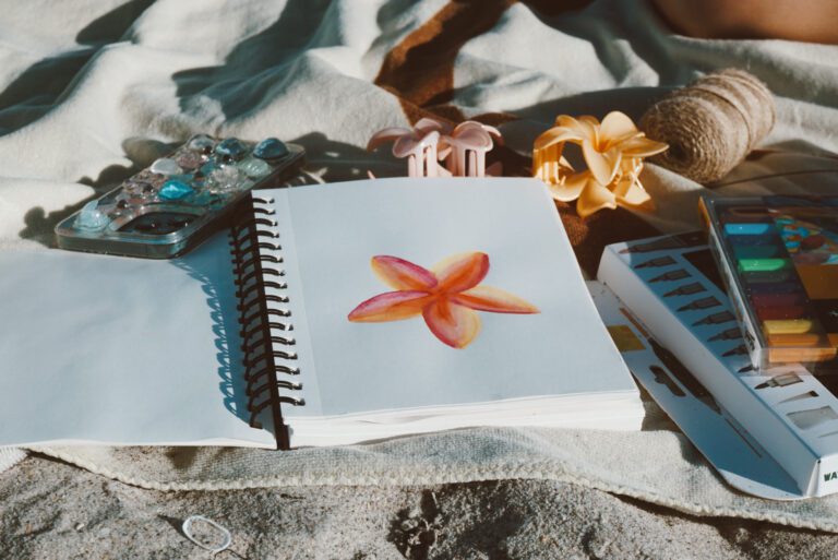 Notebook and starfish flatlay on the sand