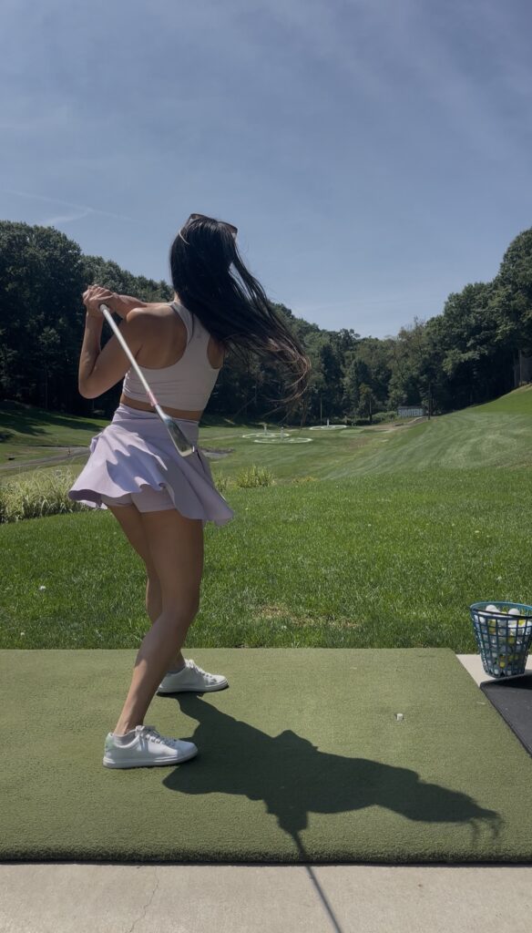 Mid-swing at the driving range
