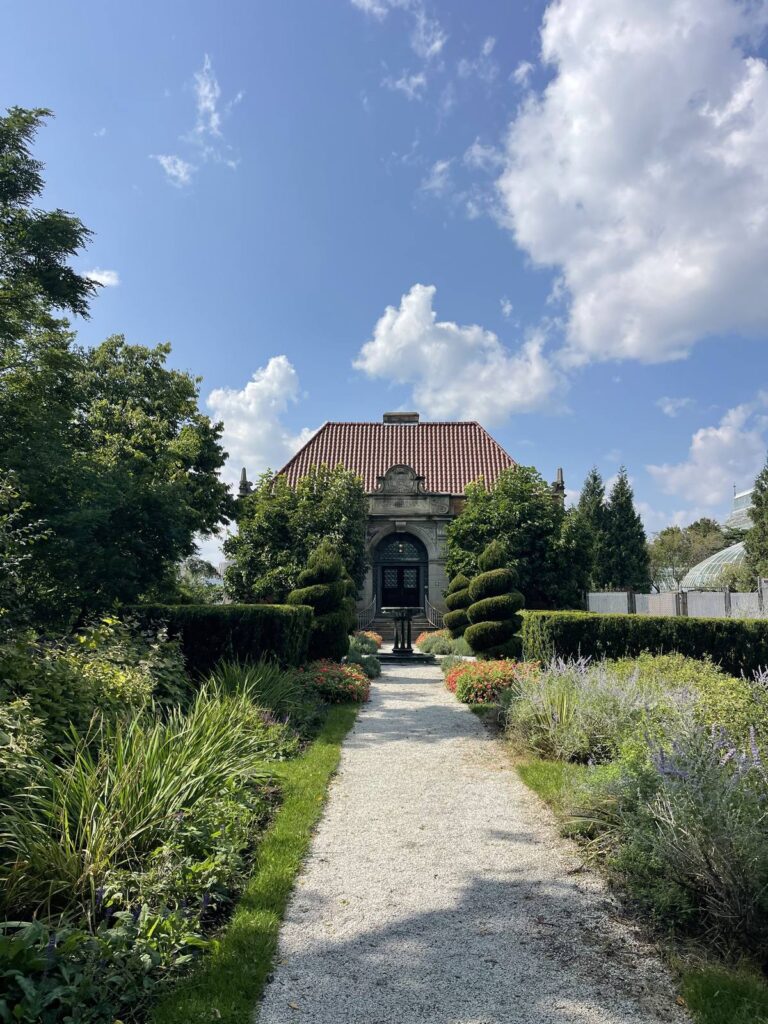 Gravel garden path leading to a stone building beside Phipps Conservatory at Schenley Park