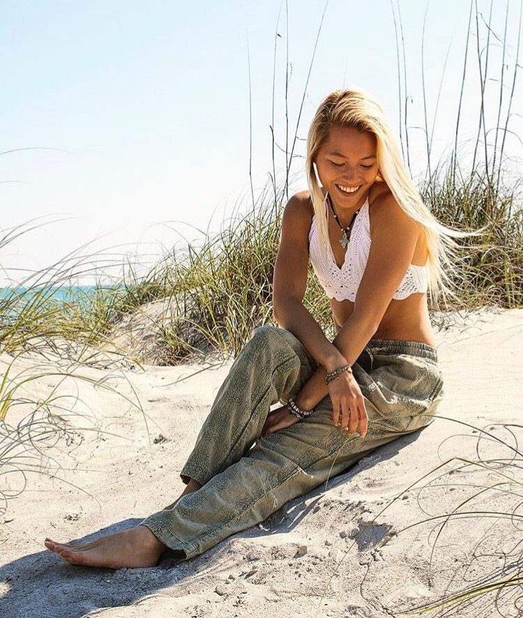 Seated in the dunes in a crochet top